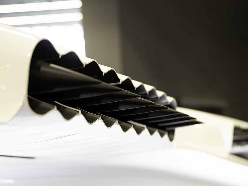 close up of row of pointed black cones against white background