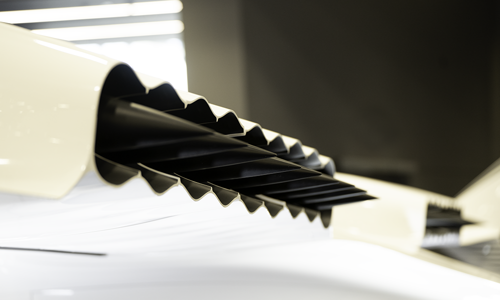 close up of row of pointed black cones against white background